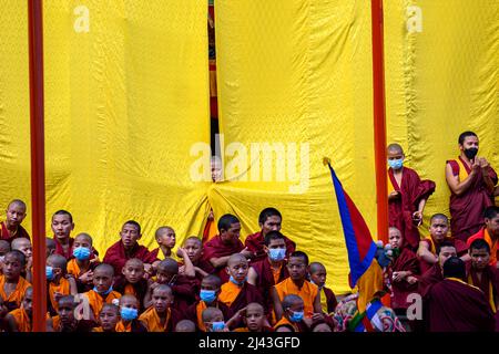 Kathmandu, Nepal. 11th Apr 2022. I giovani monaci guardano mentre gli artisti mascherati partecipano a una danza Cham spirituale e spaventata durante l'annuale festival Cham al Monastero di Shechen, Boudha. La festa della danza sacra, nota come “Cham” in lingua tibetana, commemora la nascita del guru nato dal loto, Padmasambhava. Credit: SOPA Images Limited/Alamy Live News Foto Stock