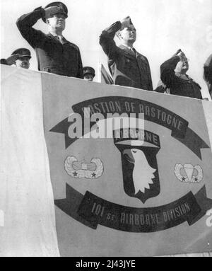 General Eisenhower CITES Airborne Division. Da sinistra a destra il generale Eisenhower, il generale maggiore Maxwell D. Taylor, il comandante della divisione e il generale Lewis R. Brereton prendono il saluto nello stand di revisione, durante la cerimonia. Per la prima volta nella storia militare degli Stati Uniti, un'intera divisione è stata citata quando il generale Eisenhower. Presidente della divisione aerea 101st un'unità presidenziale che cita per l'eroismo straordinario e la galanteria in difesa del centro di comunicazione chiave di Bastogne. Maggio 1, 1945. (Foto di stampa associata). Foto Stock