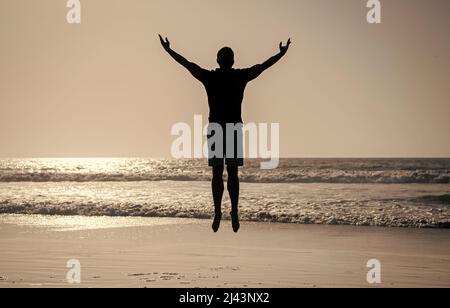 sentitevi liberi. giovani e liberi. atleta sportivo che salta nell'oceano. attività di allenamento mattutina. Foto Stock