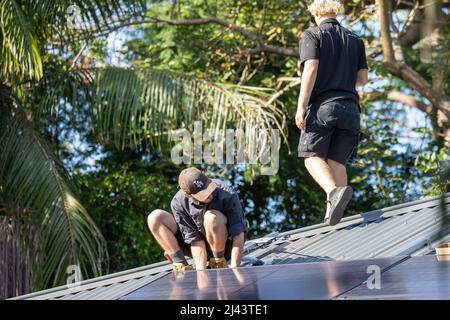 Gli installatori solari fotovoltaici montano pannelli solari REC nero alpha al tetto di una casa di Sydney, NSW, Australia Foto Stock