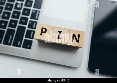 Acronimo di PIN o Personal Identification Number (numero di identificazione personale). Cubi con lettere su un computer portatile Foto Stock