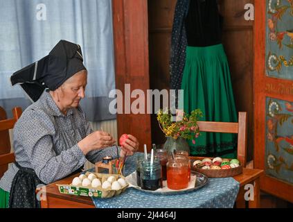 Dissen, Germania. 05th Apr 2022. Babette Zenker, direttore del Lower Sorbian Museum of Local History di Dissen, indossa un costume da lavoro Sorbian-Wendish e decora le uova di Pasqua utilizzando la tecnica del batik della cera. (A dpa con quill e cera: Pittura dell'uovo di Pasqua in Sorbia) Credit: Patrick Pleul/dpa/Alamy Live News Foto Stock