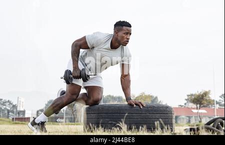 Io non esercizio per perdere peso, lo faccio per guadagnare muscolo. Sparato di un giovane maschile che si allenava con un mumbell. Foto Stock