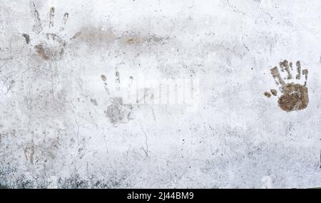 Tre stampe a mano su una vecchia parete di cemento esterna. Trama di sfondo grunge astratta. Spazio copia Foto Stock