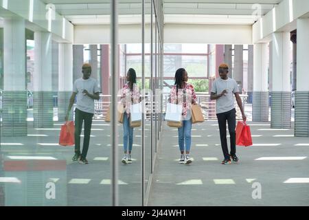 Giovane coppia nera che beve bevande rinfrescanti e shopping in corso. Foto Stock