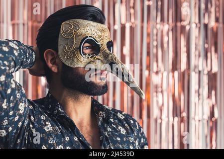 Uomo bearded in maschera tradizionale di Venezia con naso grande medio primo piano al coperto concetto di carnevale. Foto di alta qualità Foto Stock