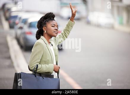 Im pronto per Vai a casa. Scatto di una giovane donna che si accaparra un taxi dopo una giornata di shopping. Foto Stock