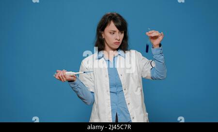 Sostanza gocciolante per ricercatori chimici in provetta con micropipetta, utilizzando apparecchiature di laboratorio per lavorare su microbiologia e esperimenti scientifici. Scienziato chimico che analizza liquido. Foto Stock