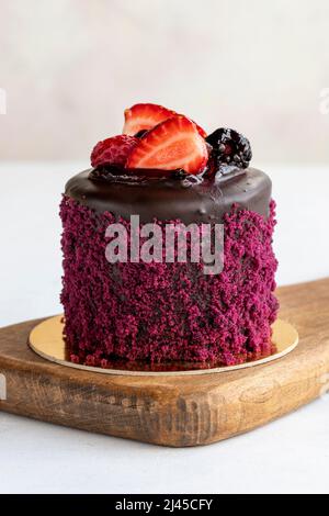 Mini torta alla fragola su sfondo bianco. Torta con ripieno di fragole e crema. Prodotti da forno. Primo piano. Foto Stock