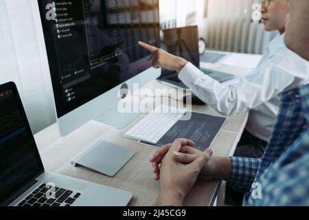 Due partnership che sviluppano tecnologie di programmazione e codifica lavorando su laptop e analizzando insieme. Foto Stock