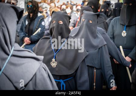 Cadice, Spagna. 11th Apr 2022. La gente partecipa alle tradizionali parate della settimana Santa o della Semana Santa a Cadice in Spagna. Ogni giorno questa settimana i Fratelli si impegnano in spettacolari processioni e bande marcianti intorno alla città che portano enormi troni raffiguranti Gesù sulla croce e la Vergine Maria. Molti indossano abiti tradizionali e cappelli alti. Credit: Julian Eales/Alamy Live News Foto Stock