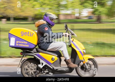 Getir conducente di consegna ultraveloce che consegna generi alimentari su uno scooter elettronico Foto Stock