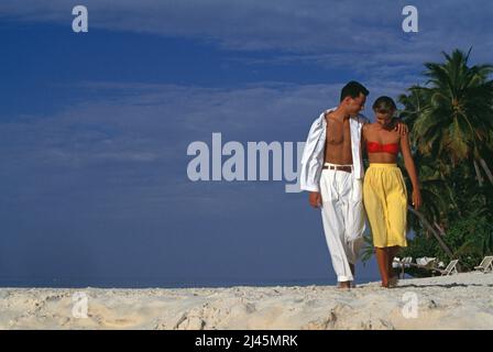 Maldive. Giovane coppia che cammina sulla spiaggia tropicale. Foto Stock