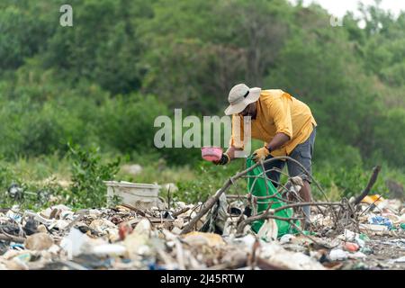 L'uomo raccoglie i rifiuti di plastica sulla spiaggia al mattino, Panama, America Centrale. Foto Stock