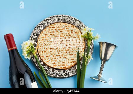 Festa di Pesah, Pasqua ebraica. Matzah e kosher rosso. Tradizionale pane ebraico rituale su sfondo blu Foto Stock