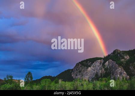 Un impressionante arcobaleno su una catena montuosa nella steppa Kuray della repubblica Altai, Russia Foto Stock