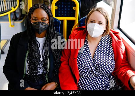 Husum, Germania. 12th Apr 2022. Ricarda Lang, (r), presidente federale di Bündnis 90/Die Grünen, e Aminata Toure, primo candidato nello Schleswig-Holstein, si siedono l'uno accanto all'altro su un autobus pubblico. Credit: Frank Molter/dpa/Alamy Live News Foto Stock