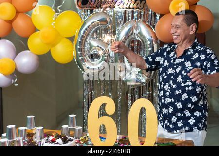 L'uomo più anziano gode di una celebrazione di compleanno mentre tiene gli sparklers Foto Stock