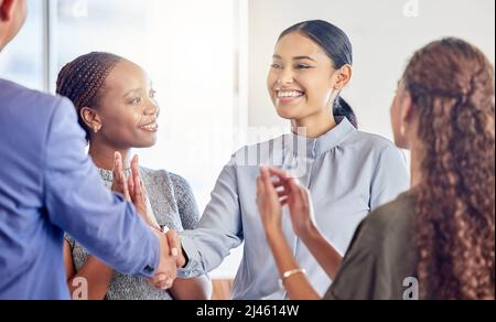 Grazie per il caldo Benvenuto. Scatto di una giovane donna d'affari che agita le mani con un collega in un ufficio al lavoro. Foto Stock