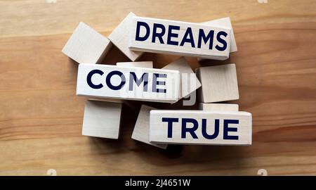 Segno di testo che mostra Dreams come True su blocchi di legno. Motivazioni citazioni ispirative per le persone di successo Foto Stock