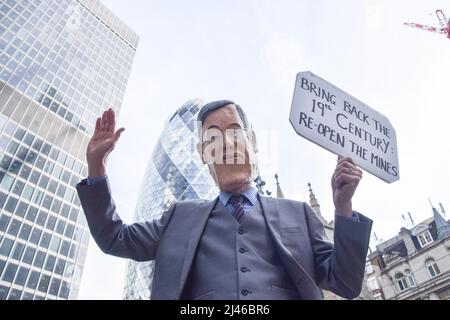 Londra, Inghilterra, Regno Unito. 12th Apr 2022. Un manifestante vestito come ministro delle opportunità della Brexit Jacob Rees-Mogg. Estinzione gli attivisti della ribellione hanno causato il caos al gigante assicurativo Lloyd's nella City di Londra, chiedendo che la società smetta di insurredire progetti di combustibili fossili. Alcuni manifestanti salirono sull'edificio e scesero striscioni, mentre altri si incollarono e si incatenarono intorno all'edificio. (Credit Image: © Vuk Valcic/ZUMA Press Wire) Foto Stock