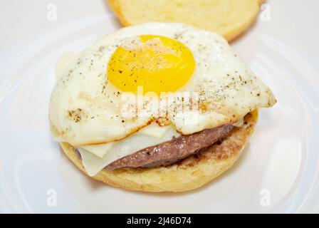 Uovo fritto in cima a un raro Cheese Burger Foto Stock