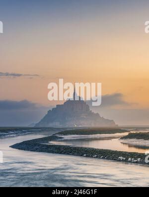 Moody Sunrise all'abbazia di le Mont Saint Michel sull'isola in nebbia mattina, Normandia, Francia settentrionale, Europa. Popolare destinazione di viaggio Foto Stock