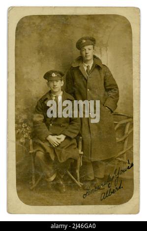 Cartolina originale dell'era WW1 di un paio di ingegneri reali, amici, i loro stemmi indicano che sono entrambi ingegneri reali. Soldati della prima guerra mondiale soldati della prima guerra mondiale. Entrambi indossano grandi cappotti, uno ha un braccio visibile, che indica che è stato ferito. Sembrano abbastanza felici da essere invalidati dalla guerra anche temporaneamente. Dallo studio di Albert England, 60 High St. Barnet, Londra, Inghilterra, Regno Unito 1914-1918 Foto Stock