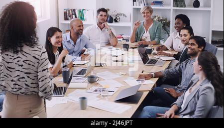 Tenere tutti informati tiene tutti in carreggiata. Shot di un gruppo di uomini d'affari che hanno una riunione in un ufficio moderno. Foto Stock