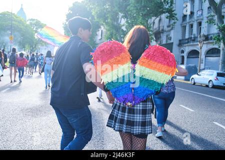 Buenos Aires, Argentina; 6 novembre 2021: LGBT Pride Parade. Giovani che marciavano verso il Congresso visto da dietro, donna con ali color arcobaleno Foto Stock