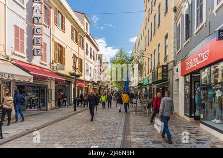 GIBILTERRA, Regno Unito - 7 APRILE 2022 - turisti e amanti dello shopping che camminano sulla strada principale in giornata di sole, nel centro di Gibilterra, nel territorio britannico d'oltremare. REGNO UNITO. Foto Stock