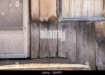 Primo piano di legno intemperiato che inizia a Rot intorno al gradino anteriore di Cottage o Casa Foto Stock