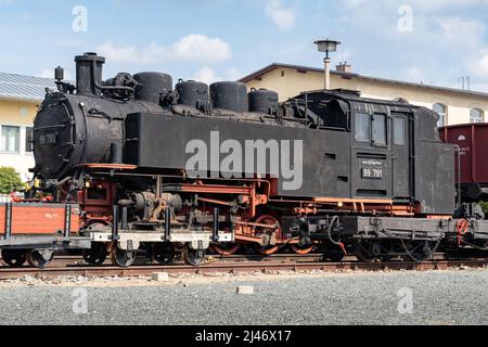 Vecchio treno a vapore in Sassonia è in piedi. Locomotiva nera della Deutsche Reichsbahn. Il veicolo è una famosa attrazione della regione. Foto Stock