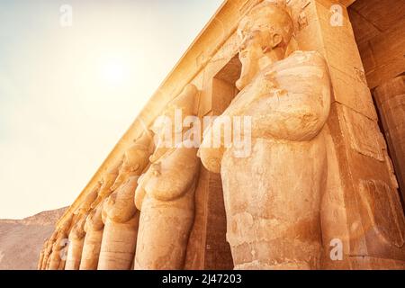Statue di faraoni come colonne nel tempio della regina Hatshepsut nella valle del Nilo a Luxor. Viaggi e turismo in Egitto Foto Stock