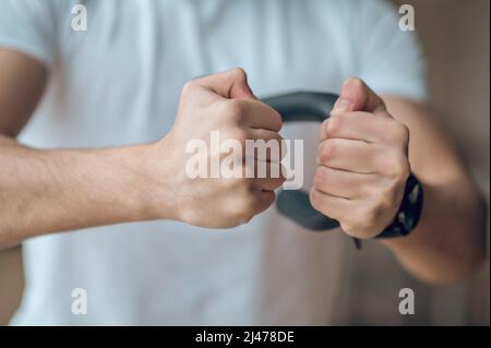 Giovane che si esercita a casa con espansore Foto Stock