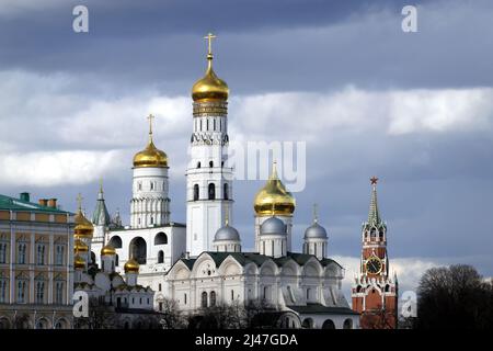 Ivan il Grande Campanile, la Torre di Spasskaya e le chiese ortodosse con cupole dorate nel Cremlino in una nuvolosa giornata primaverile Foto Stock