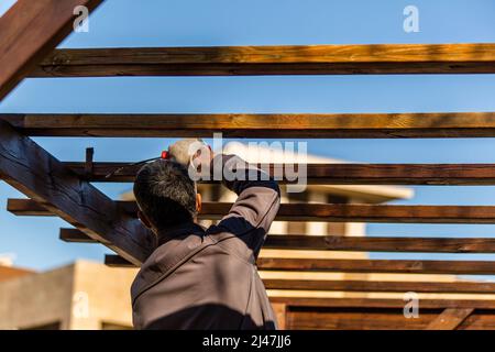 Rullo con lavori di verniciatura in legno. Vernice di noce scuro Foto Stock