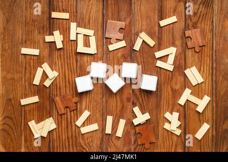 Cubi con blocchi e pezzi di puzzle su sfondo di legno Foto Stock