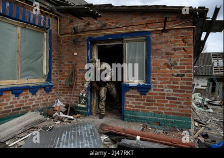 Andriivka, Kiev, Ucraina. 12th Apr 2022. Un uomo delle forze di sicurezza ha visto gettare una scatola russa vuota. Il villaggio di Andriivka, ad ovest di Kyiv, ha rivelato gravi danni, uccisioni di civili e scomparire, dopo i ritiri dei russi alla fine di marzo 2022. I residenti locali e le forze militari e di sicurezza esercitano controlli per valutare la situazione. (Credit Image: © Valeria Ferraro/ZUMA Press Wire) Foto Stock