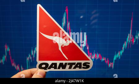 10 novembre 2021, Sydney, Australia. L'emblema della compagnia aerea Qantas sullo sfondo di un grafico dei prezzi azionari. Foto Stock