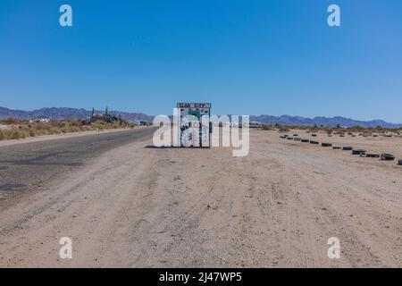 Un piccolo edificio con un murale dipinto su di esso che accoglie i visitatori di Slab City. Si tratta di una comunità off-the-grid senza servizi municipali. E 'nam Foto Stock