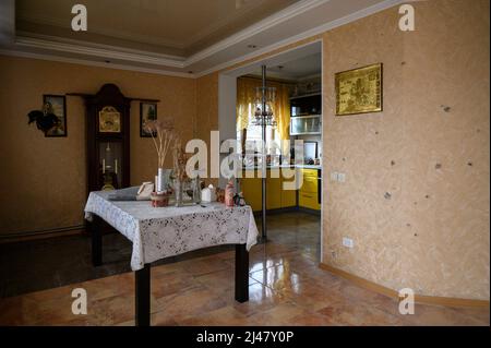 Makariv, Kiev, Ucraina. 12th Apr 2022. Vista interna di una sala da pranzo danneggiata. Il villaggio di Makariv, ad ovest di Kyiv, presenta evidenti segni di danni durante l'occupazione dei russi, durato fino alla fine di marzo 2022. I residenti cercano di affrontare la situazione, con riparazioni e controlli di base. (Credit Image: © Valeria Ferraro/ZUMA Press Wire) Foto Stock