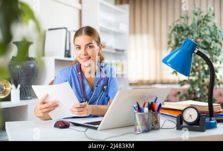 Giovane dottore femminile che lavora nel suo ufficio Foto Stock