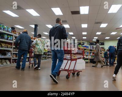 Kirkland, WA USA - circa Marzo 2022: Vista di uomini e donne con carrelli e cestini a mano, shopping all'interno di un negozio di alimentari Trader Joe. Foto Stock