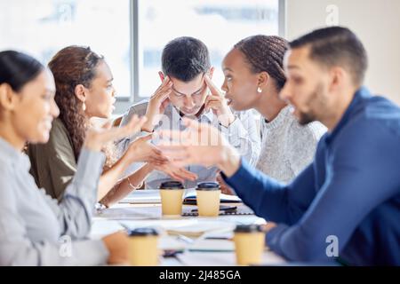 Questo giorno è troppo impegnativo. Shot di un giovane uomo d'affari che guarda sottolineato in una riunione sul lavoro. Foto Stock