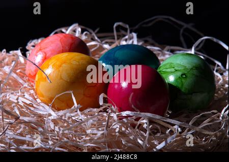 Primo piano di uova di Pasqua colorate in nido di paglia Foto Stock