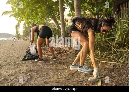 Due volontari prelevano i rifiuti sulla spiaggia. Concetto di sostenibilità del pianeta e conservazione della natura. Foto Stock