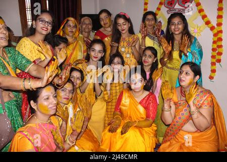 Bride indù indiano con pasta curcuma applicata sul suo volto divertirsi con la sua famiglia e amici. Concetto di matrimonio indiano Foto Stock