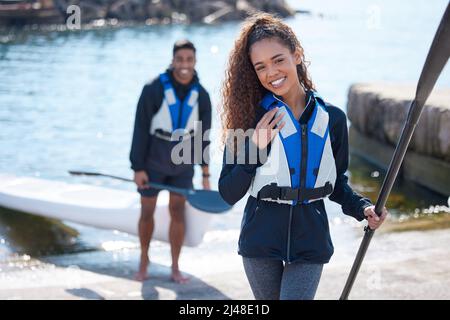 Le giornate migliori sono trascorse al lago. Ritratto di una giovane coppia che si prepara per un giro in kayak insieme a un lago. Foto Stock