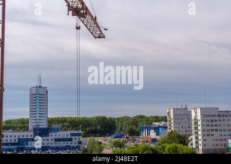 il boom della gru sulla città simboleggia la costruzione di abitazioni e lo sviluppo dell'ambiente urbano, fuoco selettivo Foto Stock